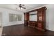 Living room with custom built-in entertainment center and hardwood floors at 12221 W Locust Ln, Avondale, AZ 85323
