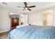Cozy bedroom featuring wood floors, ceiling fan, and dresser with TV, creating a relaxing retreat at 13218 W Crimson Ter, Peoria, AZ 85383