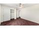 This spare bedroom has carpet flooring, neutral walls, and double doors to a closet for storage at 1478 E Spur Ave, Gilbert, AZ 85296