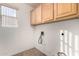 Functional laundry room with upper cabinets and utility connections at 1478 E Spur Ave, Gilbert, AZ 85296