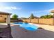 Inviting backyard pool with rock waterfall feature, surrounded by a concrete patio at 1478 E Spur Ave, Gilbert, AZ 85296