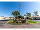 Inviting community entrance with lush landscaping, mature trees, and an American flag creating a welcoming atmosphere at 1500 N Markdale -- # 8, Mesa, AZ 85201