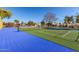 View of a tennis court surrounded by desert landscaping and mature trees at 1500 N Markdale -- # 8, Mesa, AZ 85201