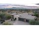 Desert home with a tile roof, three-car garage, circular drive, and mountain views in the distance at 15123 E Monument Rd, Scottsdale, AZ 85262