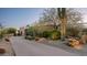 Desert home with a circular driveway and stone address marker surrounded by mature landscaping at 15123 E Monument Rd, Scottsdale, AZ 85262