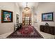 A beautiful foyer with stone floors, art, and a decorative rug leading to a custom wooden door at 15123 E Monument Rd, Scottsdale, AZ 85262