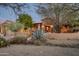 Desert home with mature landscaping, a stone facade, and warm lighting at 15123 E Monument Rd, Scottsdale, AZ 85262