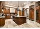 Gourmet kitchen with a large island, custom cabinets, stone floors, and high-end stainless steel appliances at 15123 E Monument Rd, Scottsdale, AZ 85262