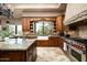 Custom kitchen with granite counters, a farmhouse sink, stainless appliances, and a view to the backyard at 15123 E Monument Rd, Scottsdale, AZ 85262