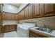 Spacious laundry room with ample cabinet space, countertops, and a utility sink at 15123 E Monument Rd, Scottsdale, AZ 85262