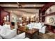 Open living room with travertine floors, stone fireplace, wood beams, and seating adjacent to the kitchen at 15123 E Monument Rd, Scottsdale, AZ 85262