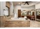Bright main bathroom featuring a soaking tub, dual vanities and wood cabinets at 15123 E Monument Rd, Scottsdale, AZ 85262