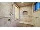 Elegant walk-in shower featuring neutral tile, a built-in bench, and glass window at 15123 E Monument Rd, Scottsdale, AZ 85262