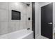 Bathroom with white tile, black accents, and a built-in shower niche at 16422 S 45Th Pl, Phoenix, AZ 85048
