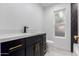 Bathroom vanity with black cabinet, gold hardware, and marble countertop at 16422 S 45Th Pl, Phoenix, AZ 85048