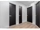 Hallway with white walls, black doors, and wood-look flooring at 16422 S 45Th Pl, Phoenix, AZ 85048
