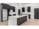 Modern kitchen with black cabinets, a white quartz island, and light wood-look floors at 16422 S 45Th Pl, Phoenix, AZ 85048