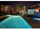 Inviting community pool with modern buildings, palm trees, and pristine blue water under the night sky at 1717 E Morten Ave # 2, Phoenix, AZ 85020