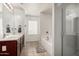 Bright bathroom featuring a double sink vanity, separate tub, and glass-enclosed shower at 25420 W Park Ave, Buckeye, AZ 85326