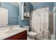 Cozy bathroom with a single vanity, decorative shelf, and a shower/tub combo with patterned curtain at 25420 W Park Ave, Buckeye, AZ 85326