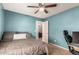 Airy bedroom with calming blue walls, ceiling fan, and doorway into another room at 25420 W Park Ave, Buckeye, AZ 85326