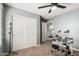 Bedroom with electric drum set, gray walls, ceiling fan, and large closet at 25420 W Park Ave, Buckeye, AZ 85326