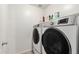 Convenient laundry room featuring modern washer and dryer, with shelving for storage at 25420 W Park Ave, Buckeye, AZ 85326