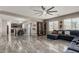 Open-concept living area featuring marble floors, a comfortable sectional, and a dining area at 25420 W Park Ave, Buckeye, AZ 85326
