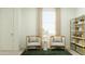 Comfortable sitting area with two chairs, round table, and stylish shelving unit under a window at 2940 N 98Th Ln, Phoenix, AZ 85037