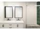 Modern bathroom featuring double sinks, white cabinets and a glass-enclosed shower with green tile accent at 3141 E Hillery Dr, Phoenix, AZ 85032