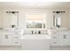 Elegant bathroom with dual vessel sinks, white countertops, a soaking tub, and modern fixtures at 3141 E Hillery Dr, Phoenix, AZ 85032
