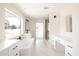 Bright bathroom showcasing a soaking tub, dual vanities, and large window providing natural light at 3141 E Hillery Dr, Phoenix, AZ 85032
