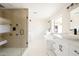 Modern bathroom featuring a glass-enclosed shower, soaking tub, dual vanities, and white marble floors at 3141 E Hillery Dr, Phoenix, AZ 85032