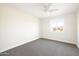 Minimalist bedroom with neutral carpet, a ceiling fan, and a window providing natural light at 3141 E Hillery Dr, Phoenix, AZ 85032