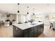 Open-concept layout featuring a kitchen island with seating and a view into the living and dining areas at 3141 E Hillery Dr, Phoenix, AZ 85032