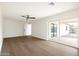 Bright living room features wood floors, a ceiling fan and sliding glass doors leading to the backyard at 3141 E Hillery Dr, Phoenix, AZ 85032