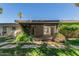 The covered patio overlooks the lush backyard with stepping stone pathway and a palm tree at 3229 E Malapai Dr, Phoenix, AZ 85028