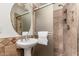 Updated bathroom featuring a sink with pedestal, shower and large round mirror at 3229 E Malapai Dr, Phoenix, AZ 85028
