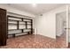 Spacious bedroom features built-in shelving and terracotta tiled flooring to the attached bathroom at 3229 E Malapai Dr, Phoenix, AZ 85028