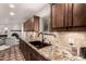 Kitchen with granite countertop, tile backsplash, wood cabinetry, and black sink at 3229 E Malapai Dr, Phoenix, AZ 85028