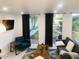 Bright living room with stylish furnishings, dark drapes, and backyard view at 3229 E Malapai Dr, Phoenix, AZ 85028