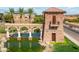 Community entrance featuring stone tower, water feature, mature landscaping, and neighborhood sign at 36001 W San Ildefanso Ave, Maricopa, AZ 85138