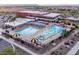 Aerial view of a community swimming pool with water slides and sun umbrellas at 36020 W San Ildefanso Ave, Maricopa, AZ 85138