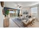 Open-concept living room with a large sliding door to the backyard, stylish furniture, and neutral decor at 36020 W San Ildefanso Ave, Maricopa, AZ 85138