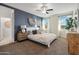 Relaxing main bedroom with accent wall, ceiling fan, plush bedding, and ample natural light at 36020 W San Ildefanso Ave, Maricopa, AZ 85138