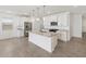 Open kitchen showcases a large island with granite countertops, stainless steel appliances, and sleek white cabinets at 3732 S 87Th Dr, Tolleson, AZ 85353