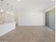 Living room featuring tile floors, white walls, and modern lighting, with a sliding glass door to the patio at 3732 S 87Th Dr, Tolleson, AZ 85353