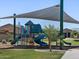 Community playground with colorful play structures, shade canopy, and green grass for Gathering fun at 3814 S 87Th Dr, Tolleson, AZ 85353