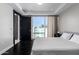 Comfortable bedroom with a queen-size bed, sleek black door frame, and hardwood floors at 4422 N 75Th St # 6007, Scottsdale, AZ 85251
