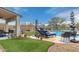 Relaxing backyard oasis with a sparkling pool, lounge chairs, barbecue, and well-manicured artificial turf at 4514 E Coyote Wash Dr, Cave Creek, AZ 85331